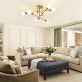 Modern living room with beige sectional sofa, ottoman, and decorative items.